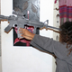Toveet Radcliffe’s sister demonstrates with a paper gun the angle it would have had to be placed to re-create the shot in her sister’s forehead. (David Sheen)